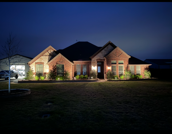 A large brick house is lit up at night