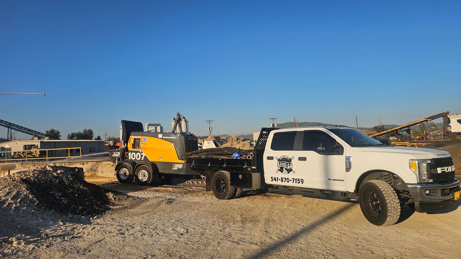 Concrete pumping equipment staged for industrial concrete project at gravel yard