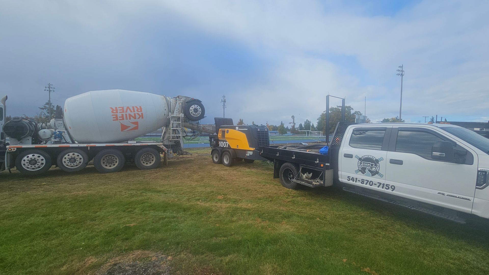 Concrete pumping equipment setup near athletic field for slab or sidewalk installation