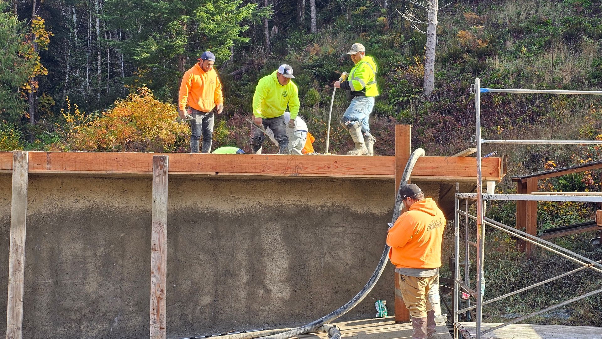 Elevated slab pour with concrete crew using pump hose on raised structure