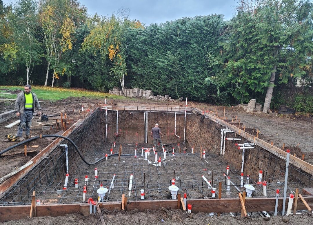 In-ground pool construction with rebar framing and plumbing setup for concrete pour