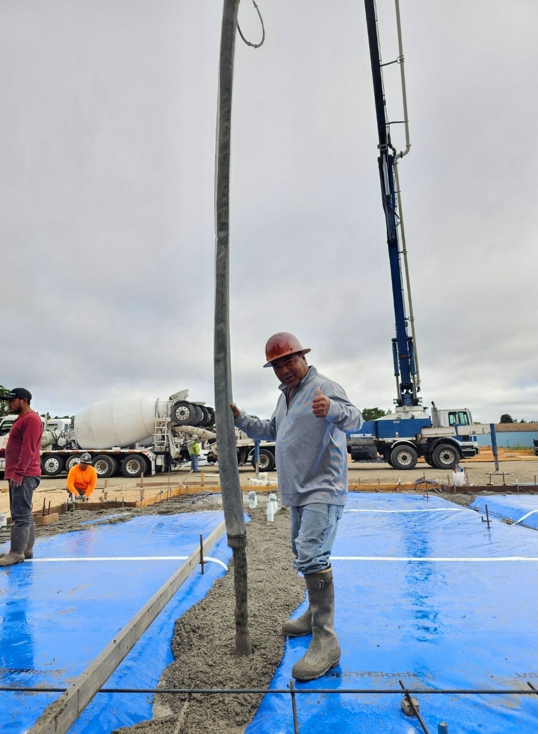 Concrete contractor using boom pump for slab installation on commercial construction site
