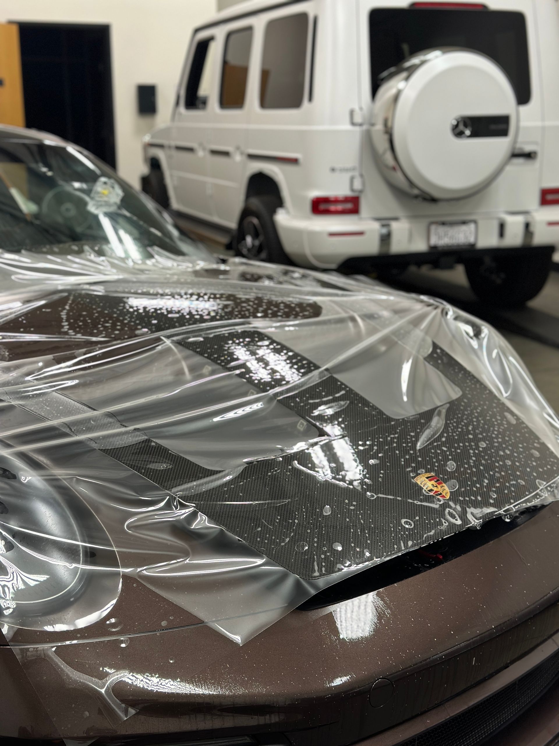 The hood of a car is covered in clear plastic