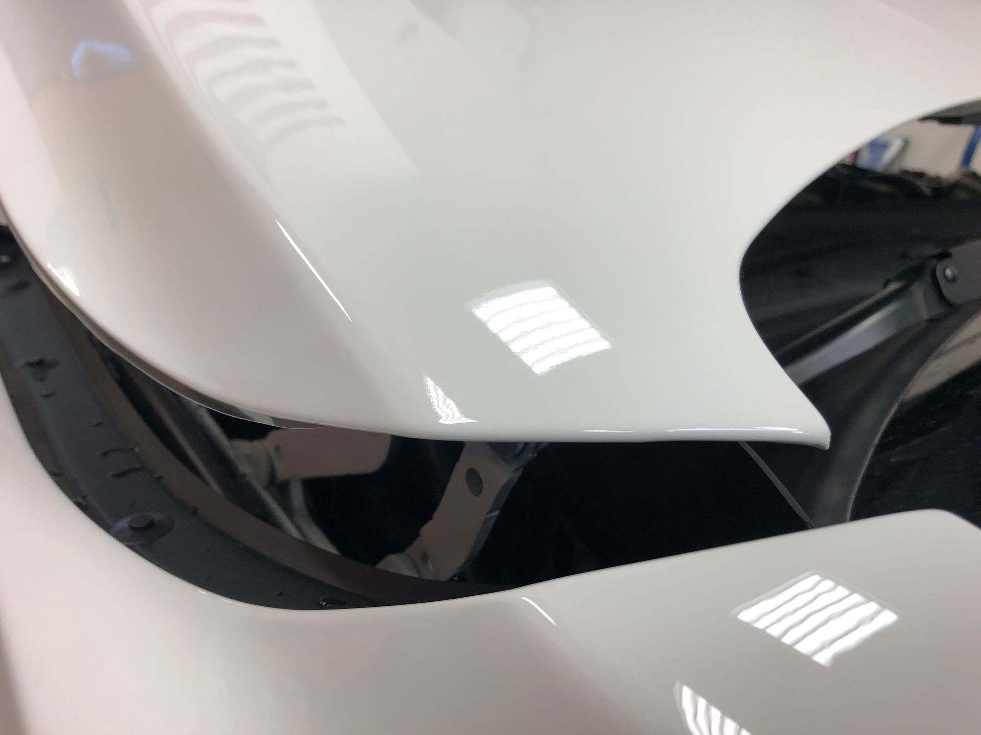 A close up of a white car with the hood open