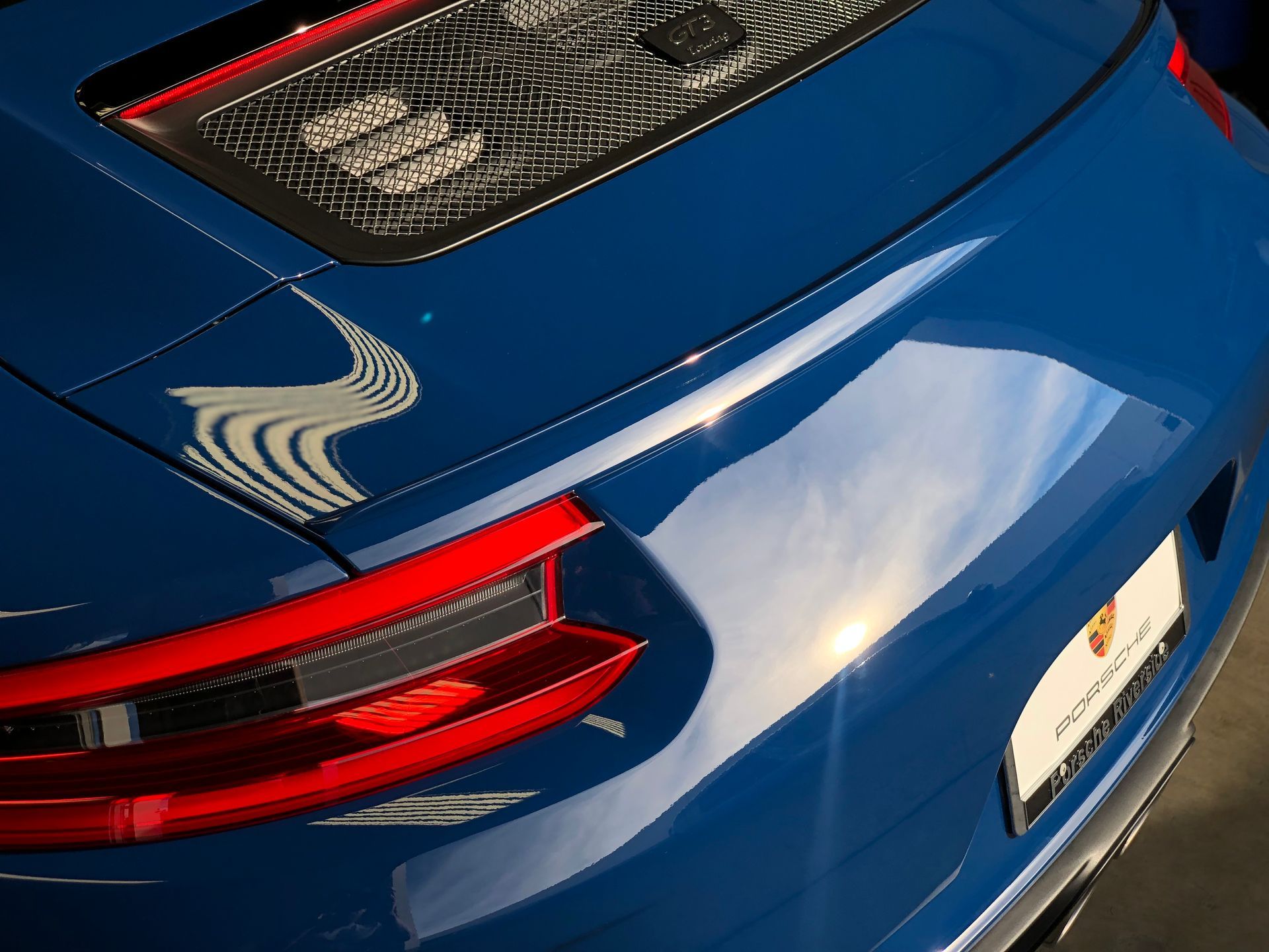 A close up of the back of a blue porsche 911