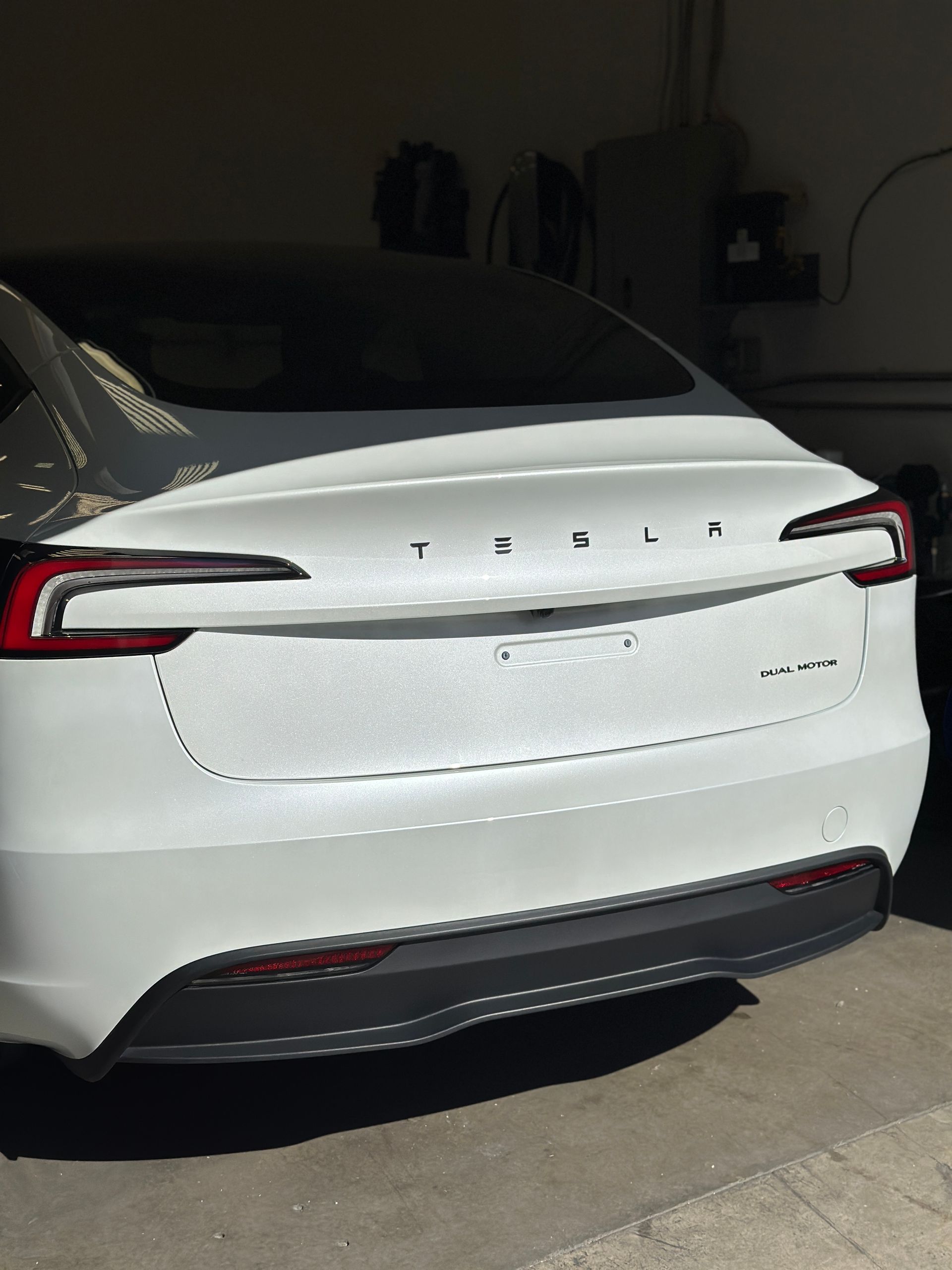 A white tesla model s is parked in a garage