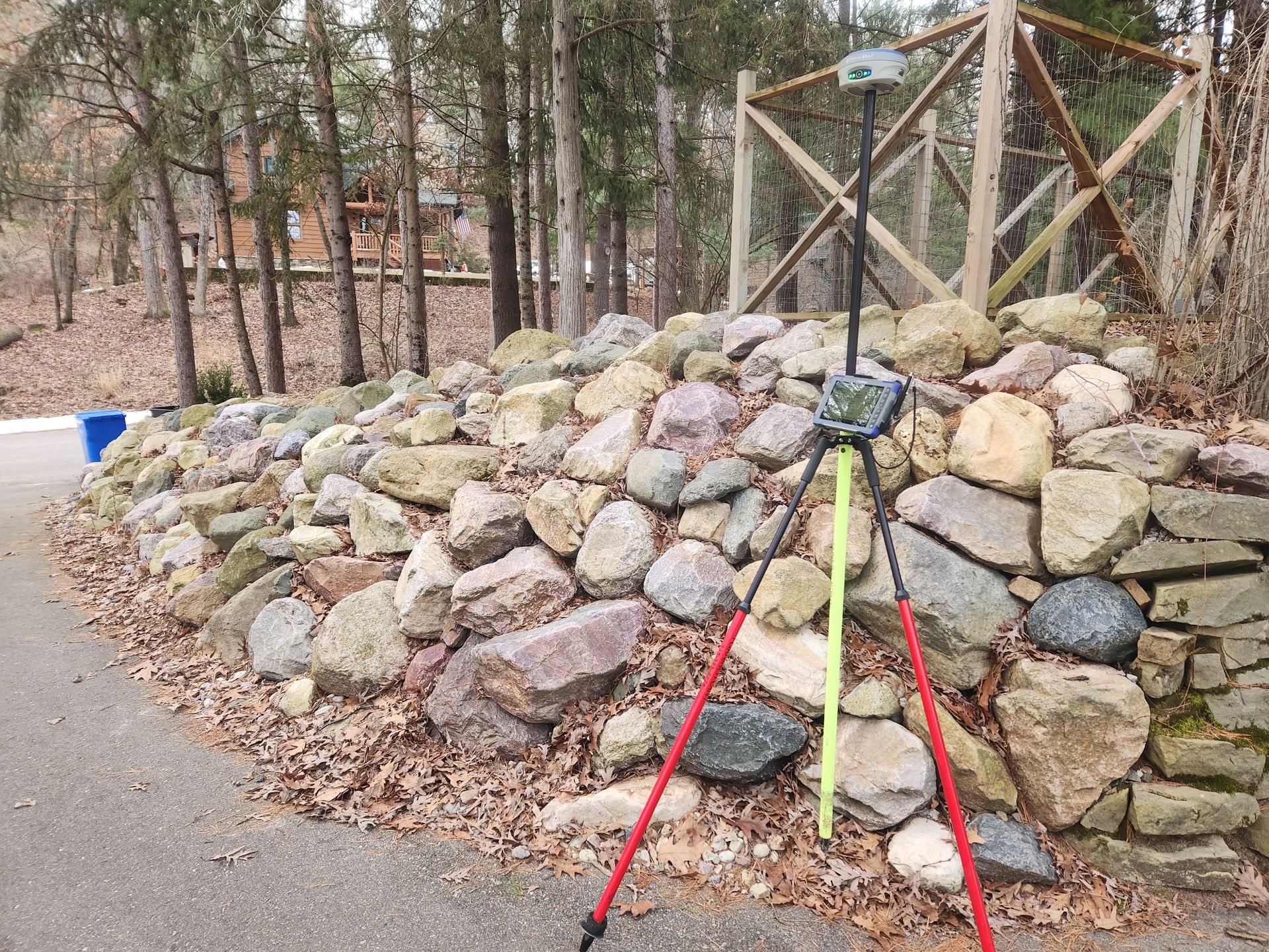 A row of construction vehicles are parked in a dirt field.