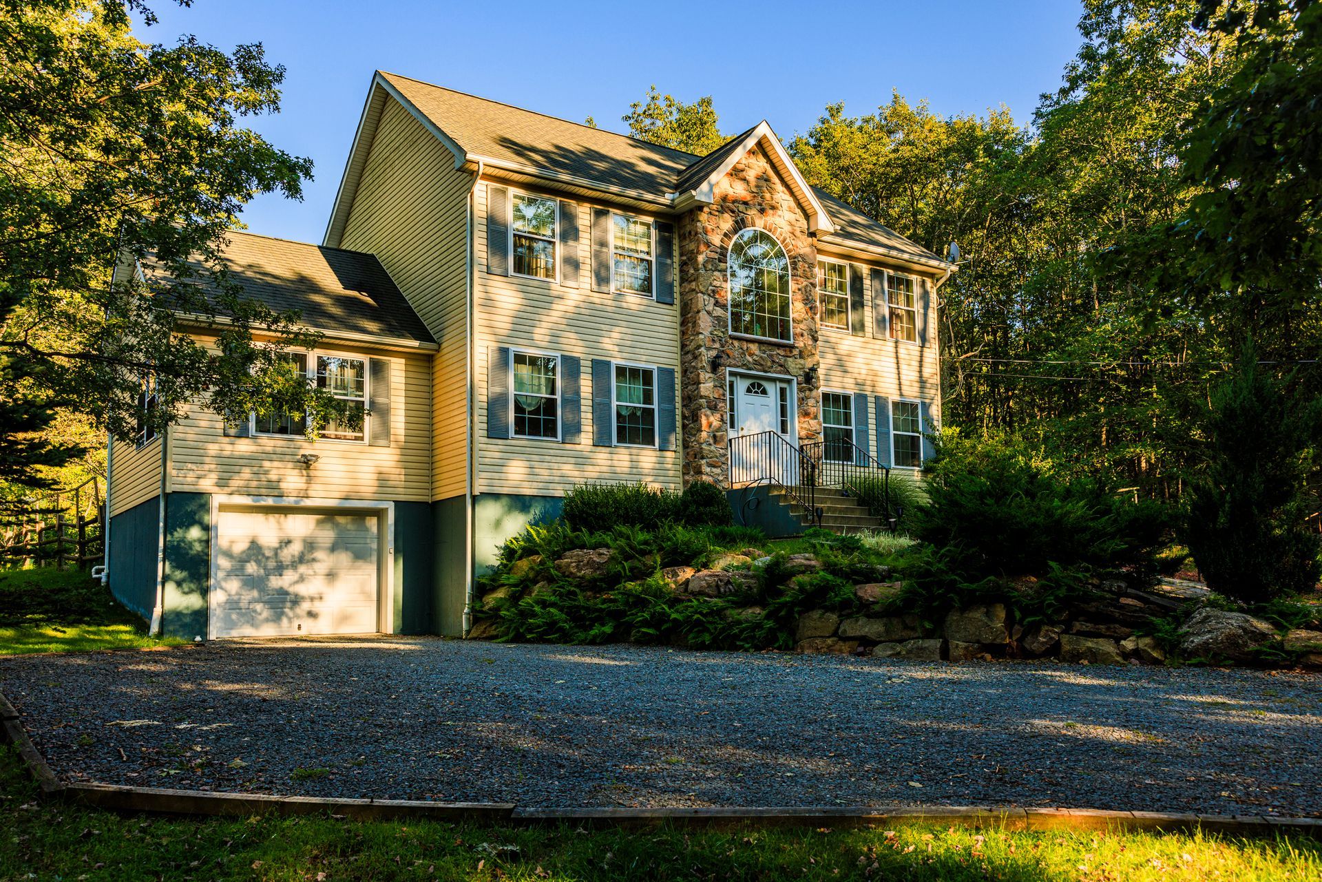 A large house with a gravel driveway in front of it