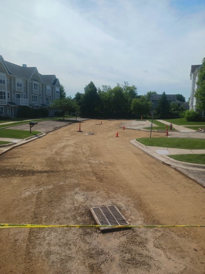 A dirt road is being built in front of a brick building.