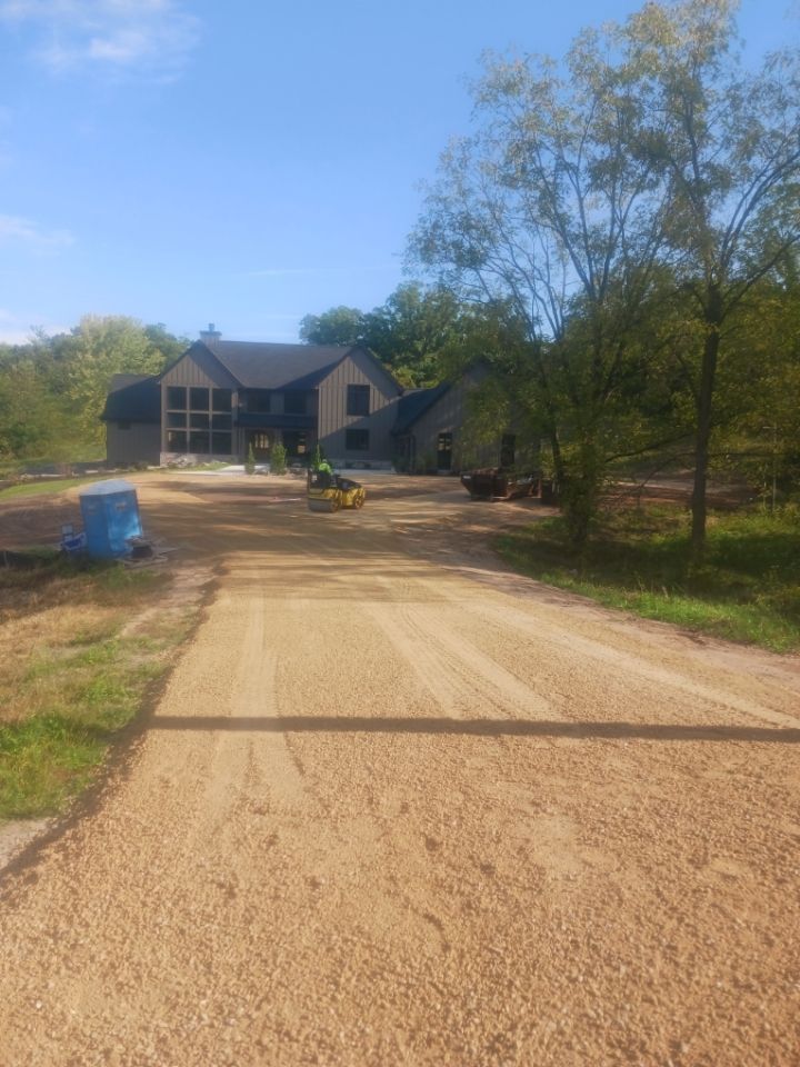 A yellow roller is rolling asphalt on a brick sidewalk.