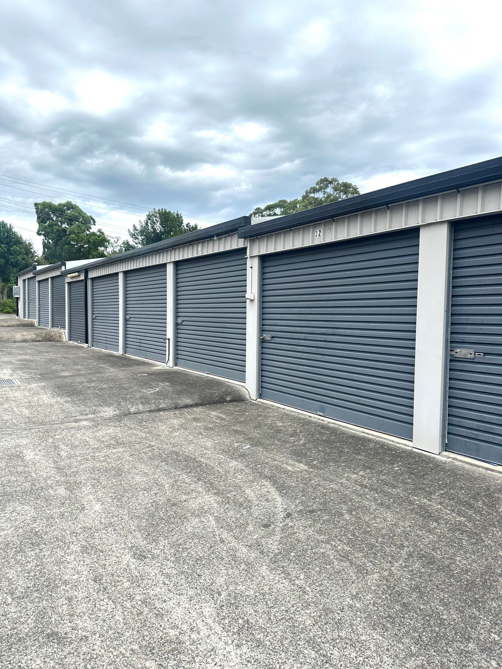 A row of garages with roller doors on a cloudy day.— Coolabah Self Storage In Wingham, NSW