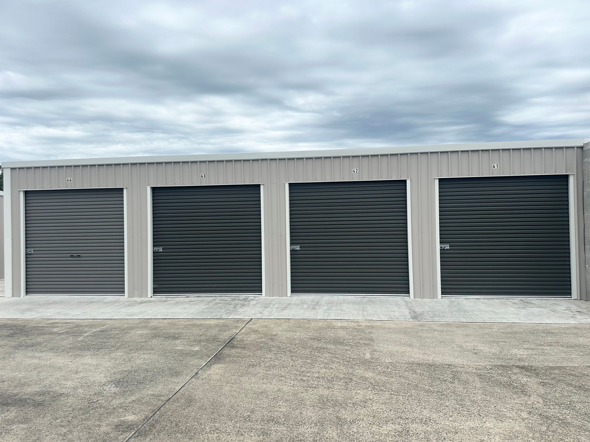 A Row of Storage Units With Blue Doors on a Sunny Day — Coolabah Self Storage In Taree, NSW