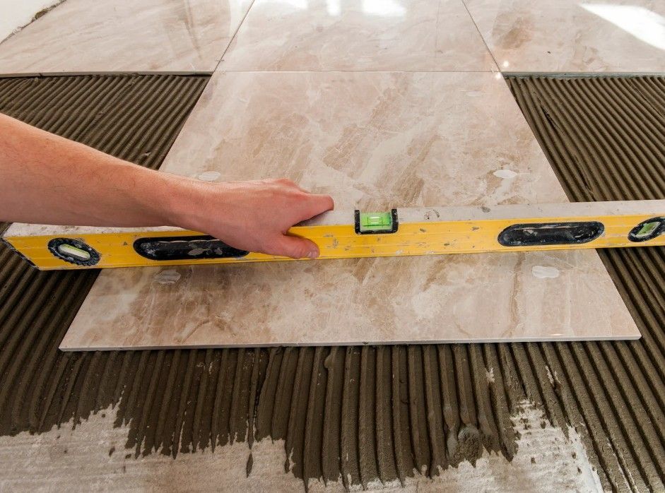 Derbyshire Tiling Specialists checking the level of large porcelain floor tiles  placed onto adhesive in Derby