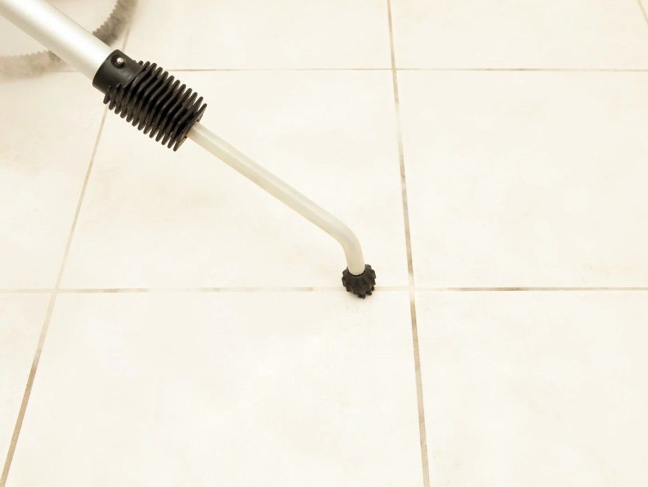 close up of Derbyshire Tiling Specialists steam cleaning dirty grout between floor tiles at a property in Derby