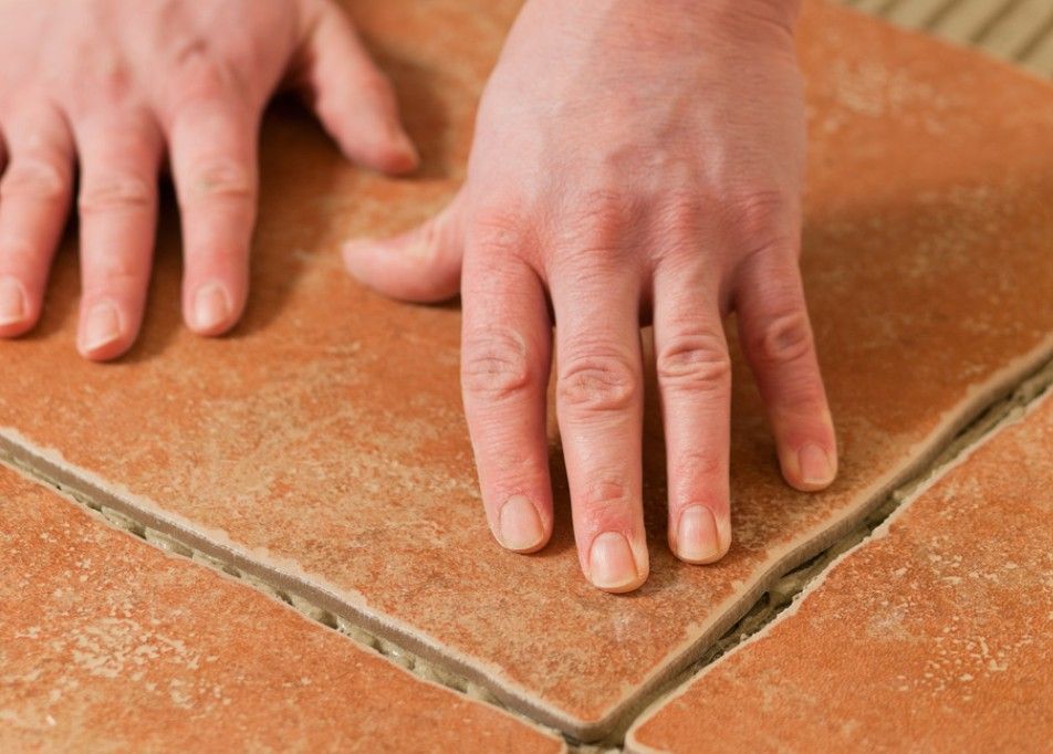 Derbyshire Tiling Specialists fitting traditional terracotta stone tiles onto a floor in a  hallway in Derby.