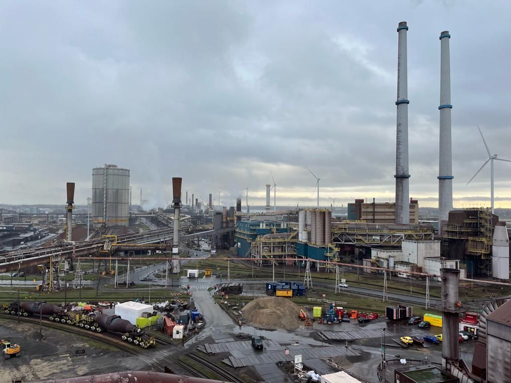 An aerial view of a large industrial area with a lot of buildings and chimneys.