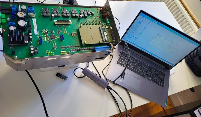 A laptop is sitting next to a motherboard on a table.