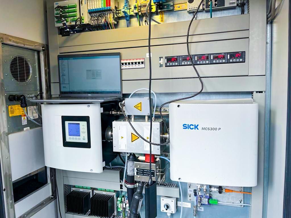 A laptop computer is sitting on top of a control panel.