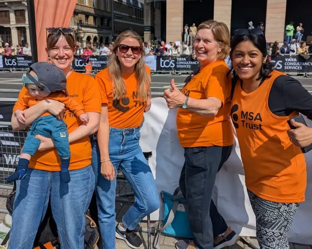 A group of women wearing orange shirts are posing for a picture.