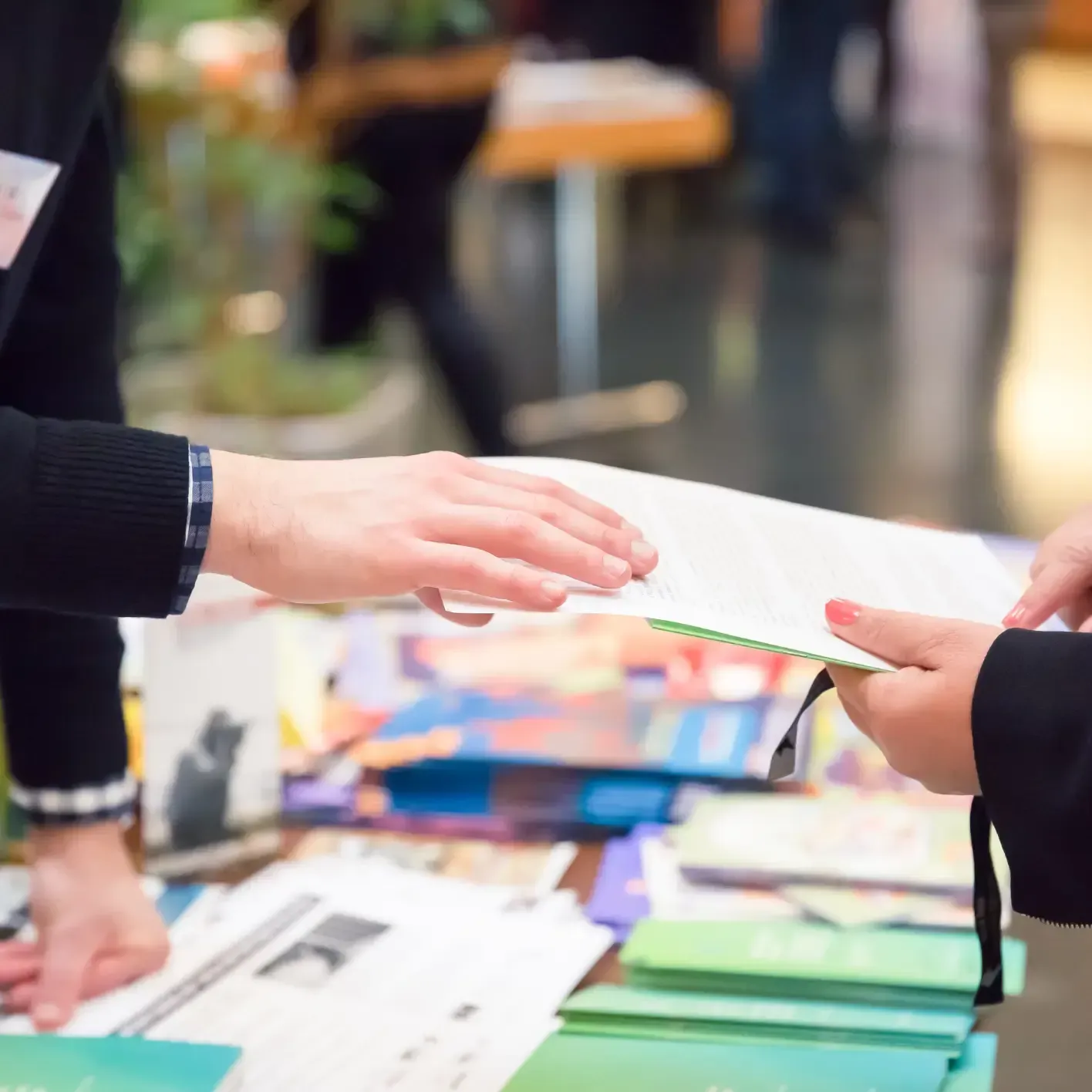 A person is handing a piece of paper to another person.