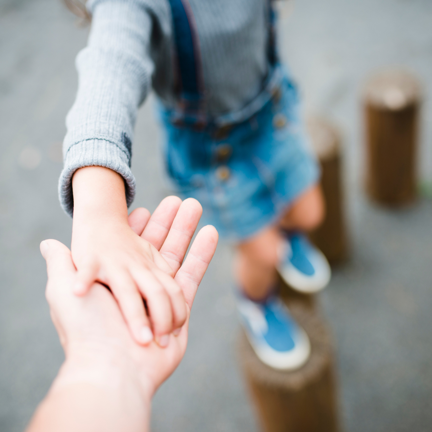 A close up of a person holding a child 's hand.