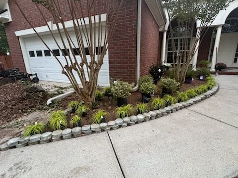 A brick house with a lush green garden in front of it.