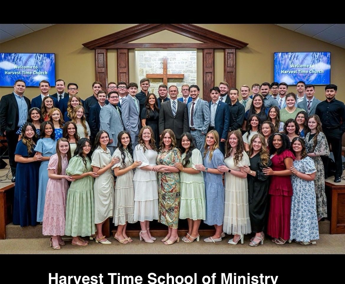 a group of young people standing in front of stained glass and a cross