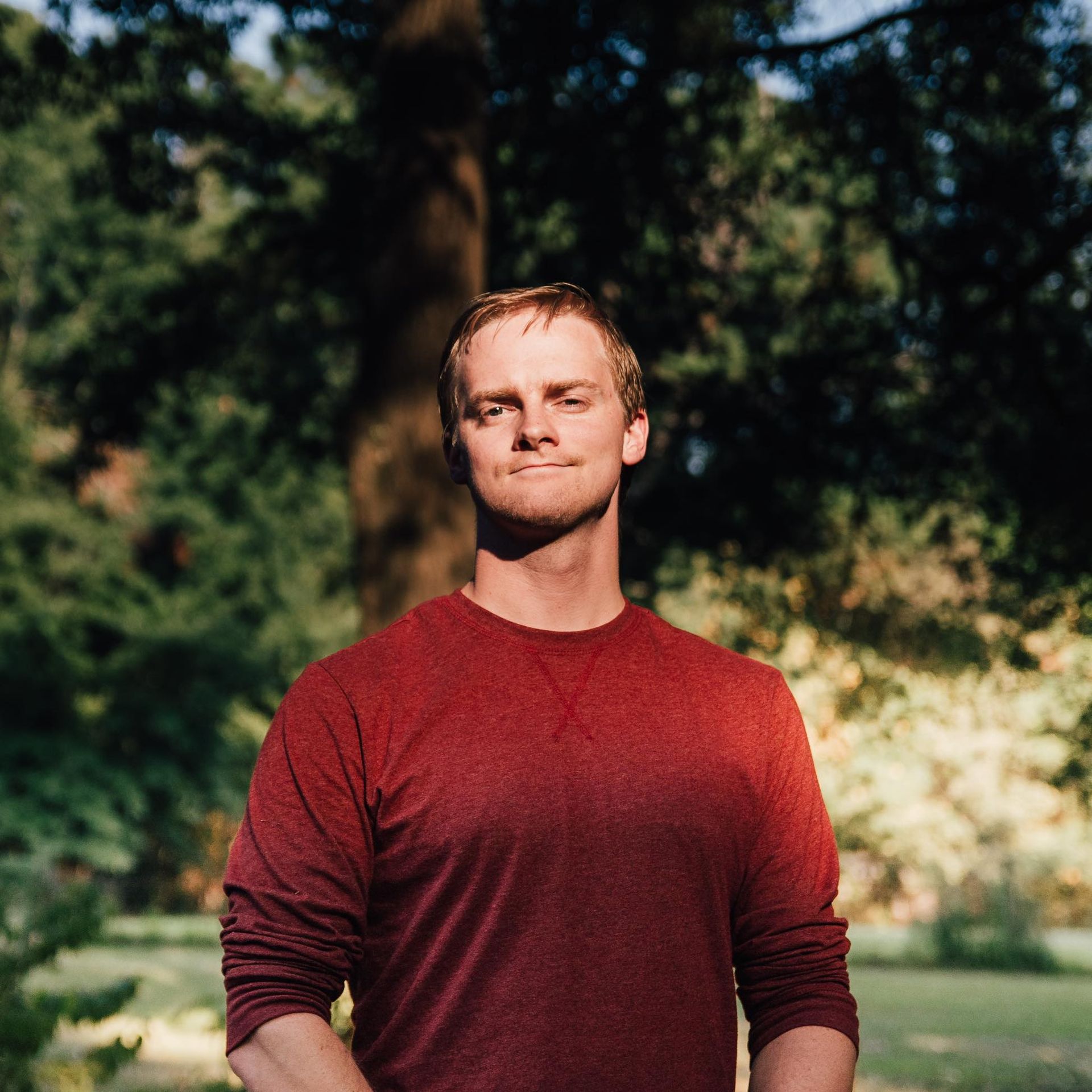 young man in red shirt cocky smile