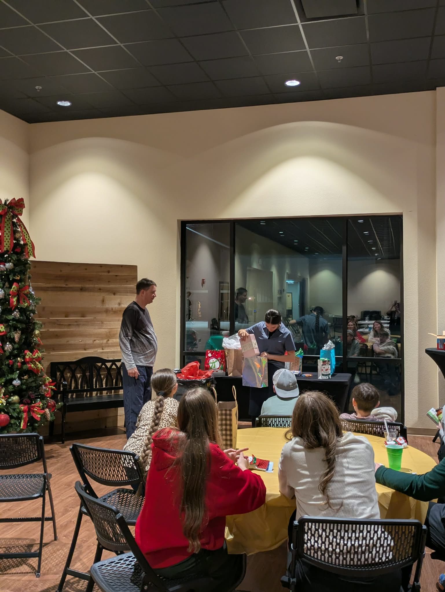 youth standing around watching one open a gift