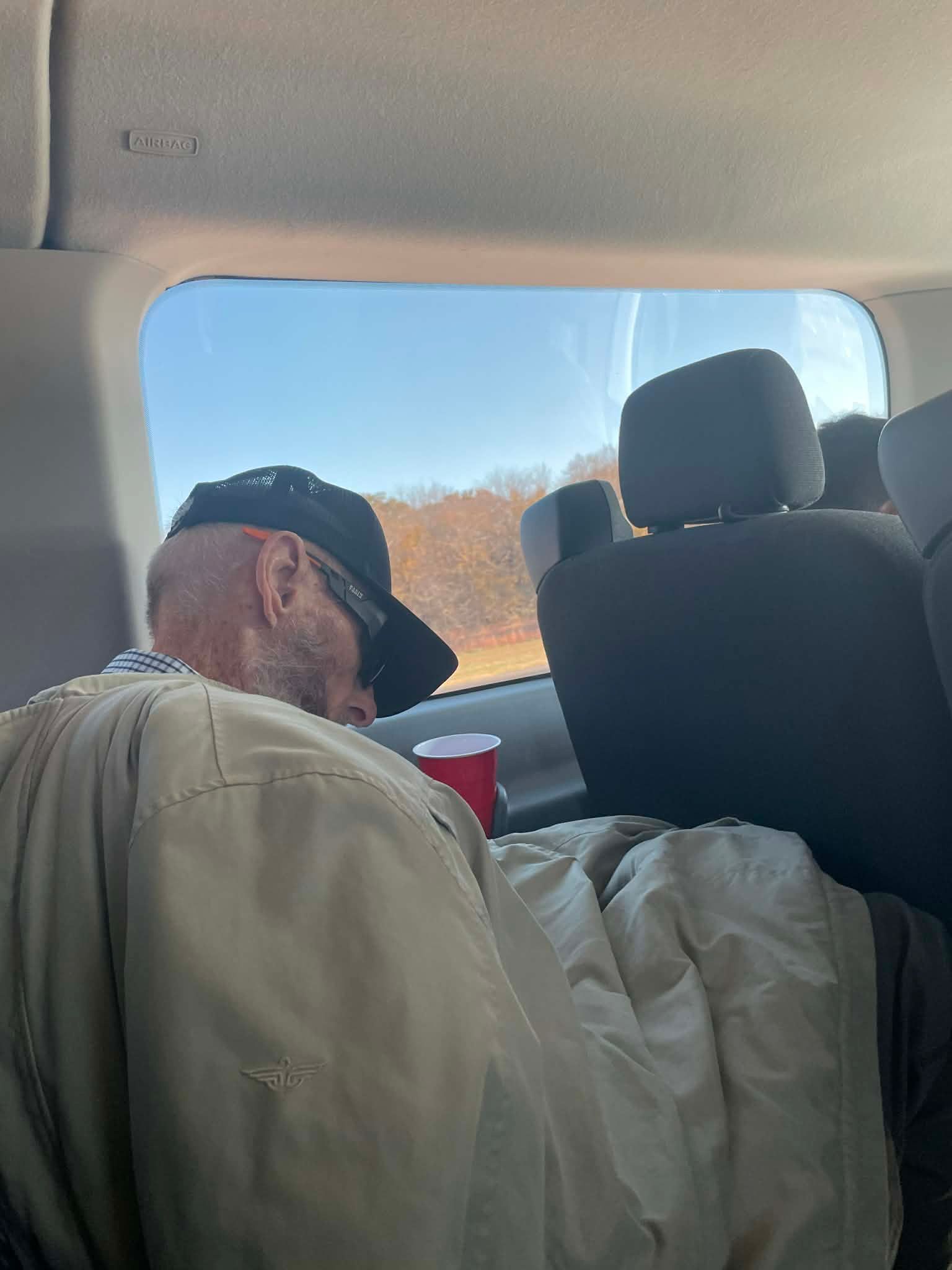 man asleep holding red cup