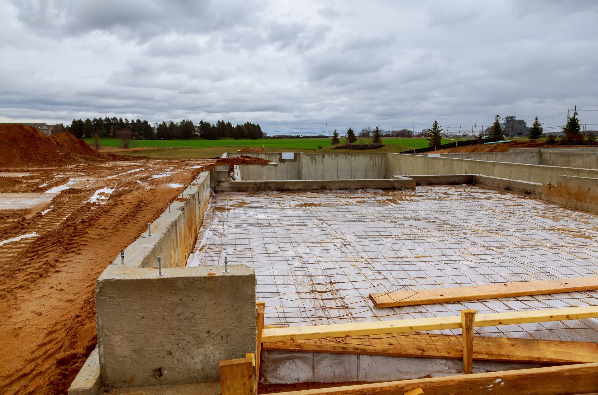 A concrete foundation is being built on a cloudy day.