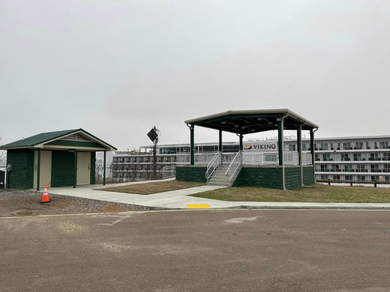 There is a gazebo in the middle of a parking lot.