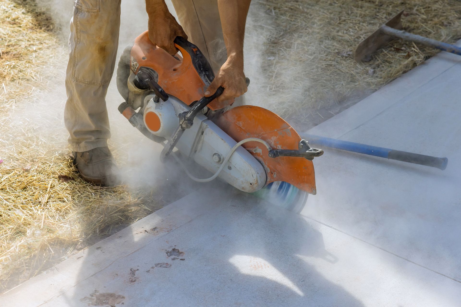 A man is using a circular saw to cut concrete.