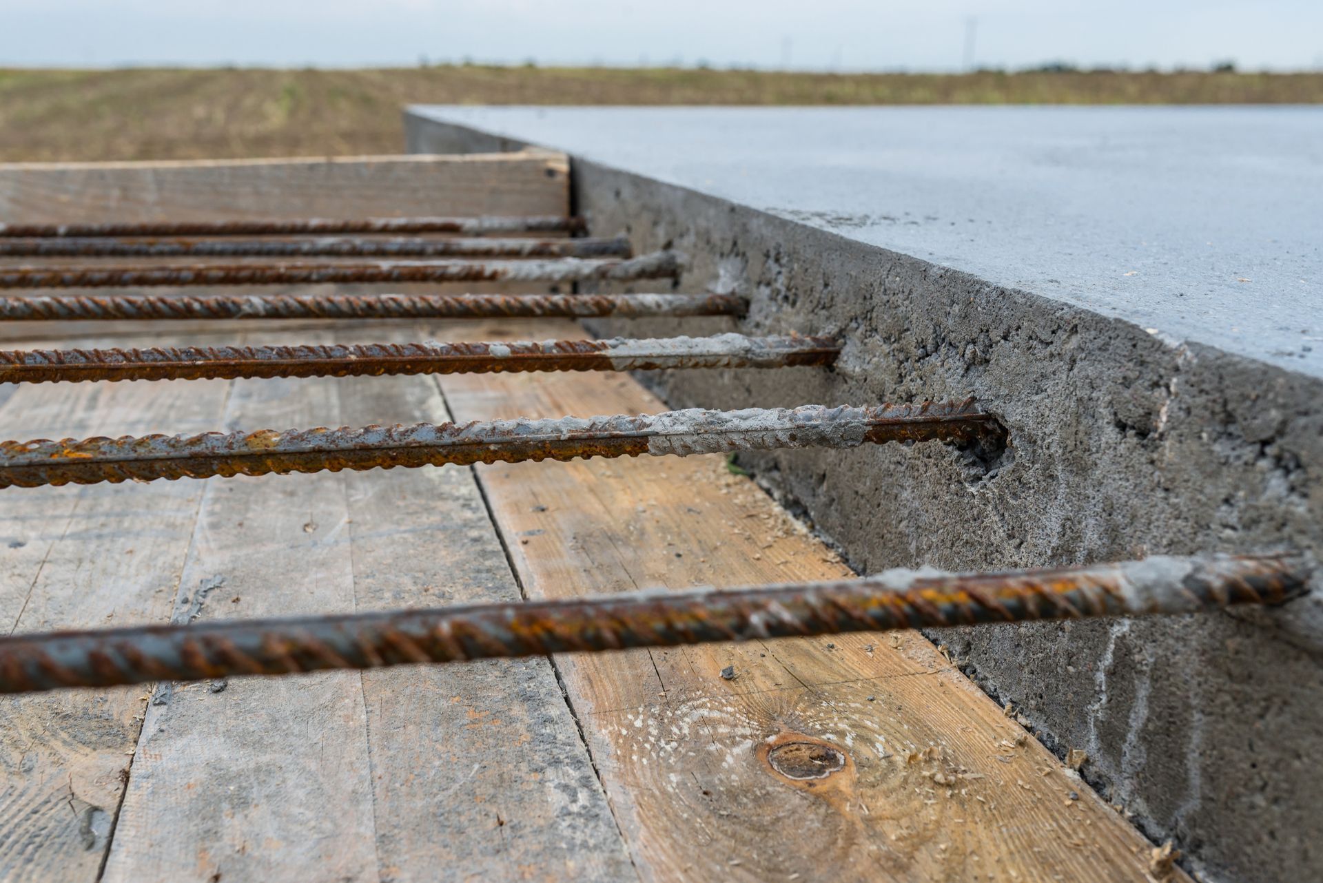 A close up of a concrete foundation being built on a wooden floor.