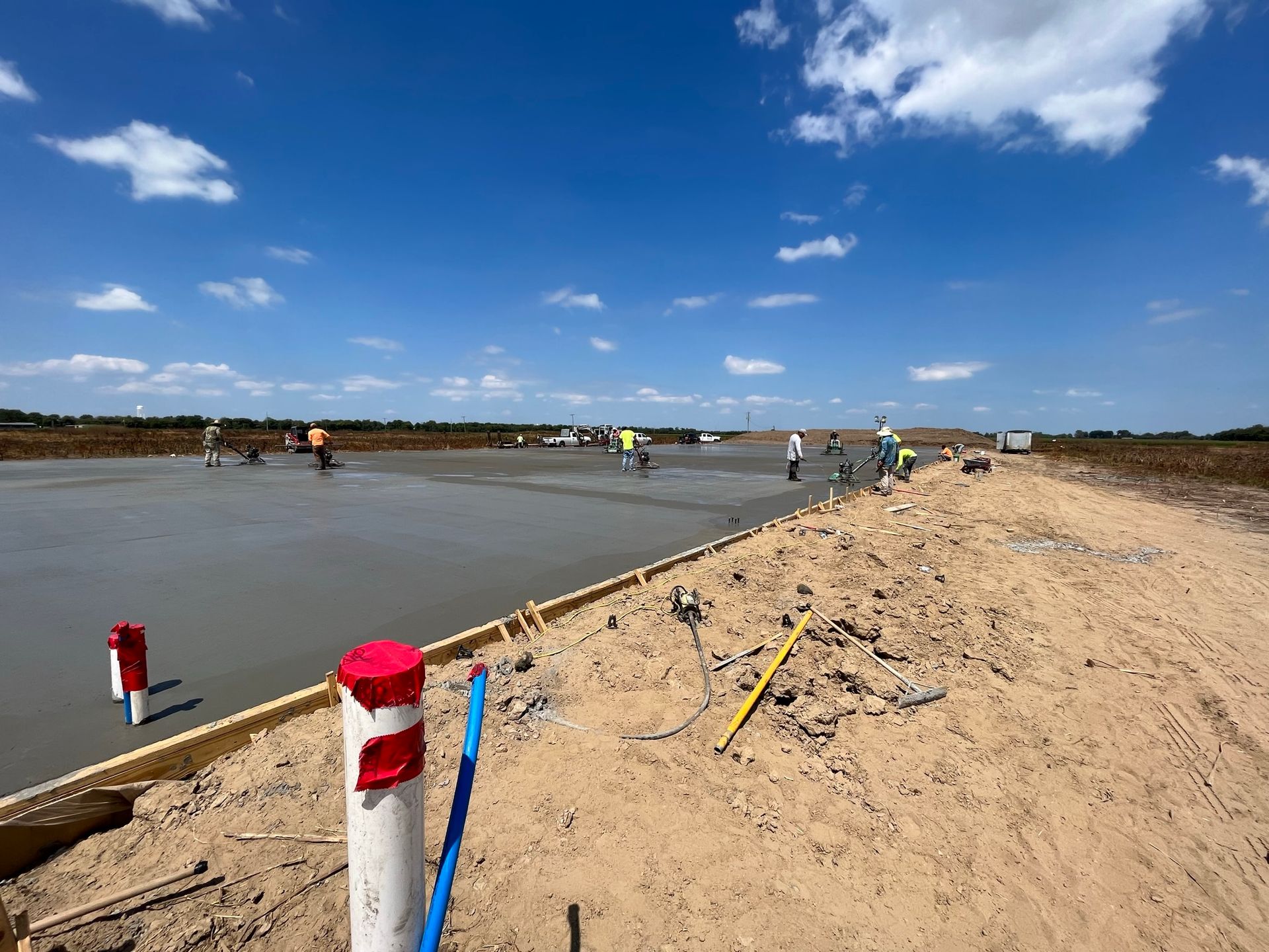 A group of construction workers are working on a concrete surface.