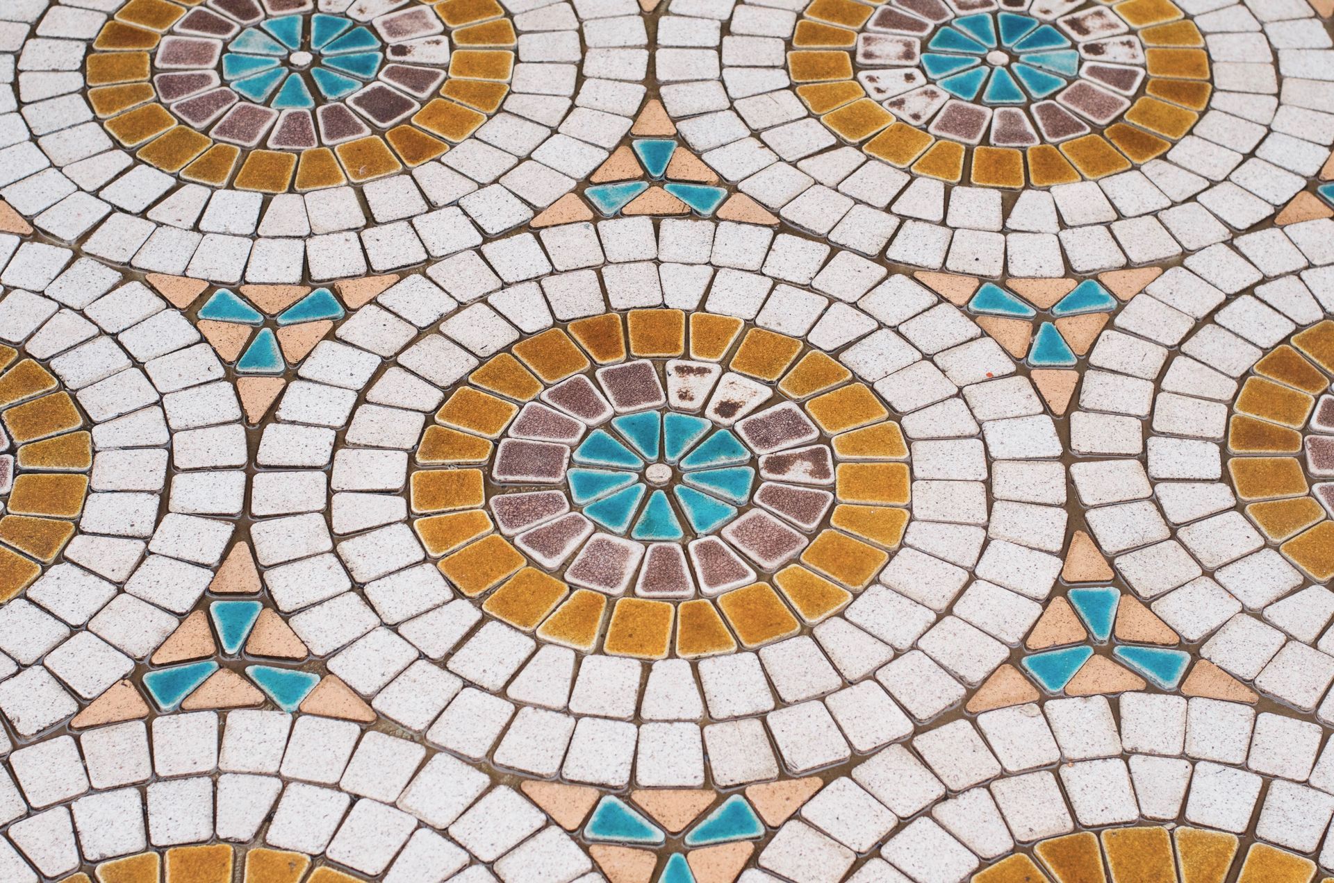 A close up of a mosaic floor with a circular pattern