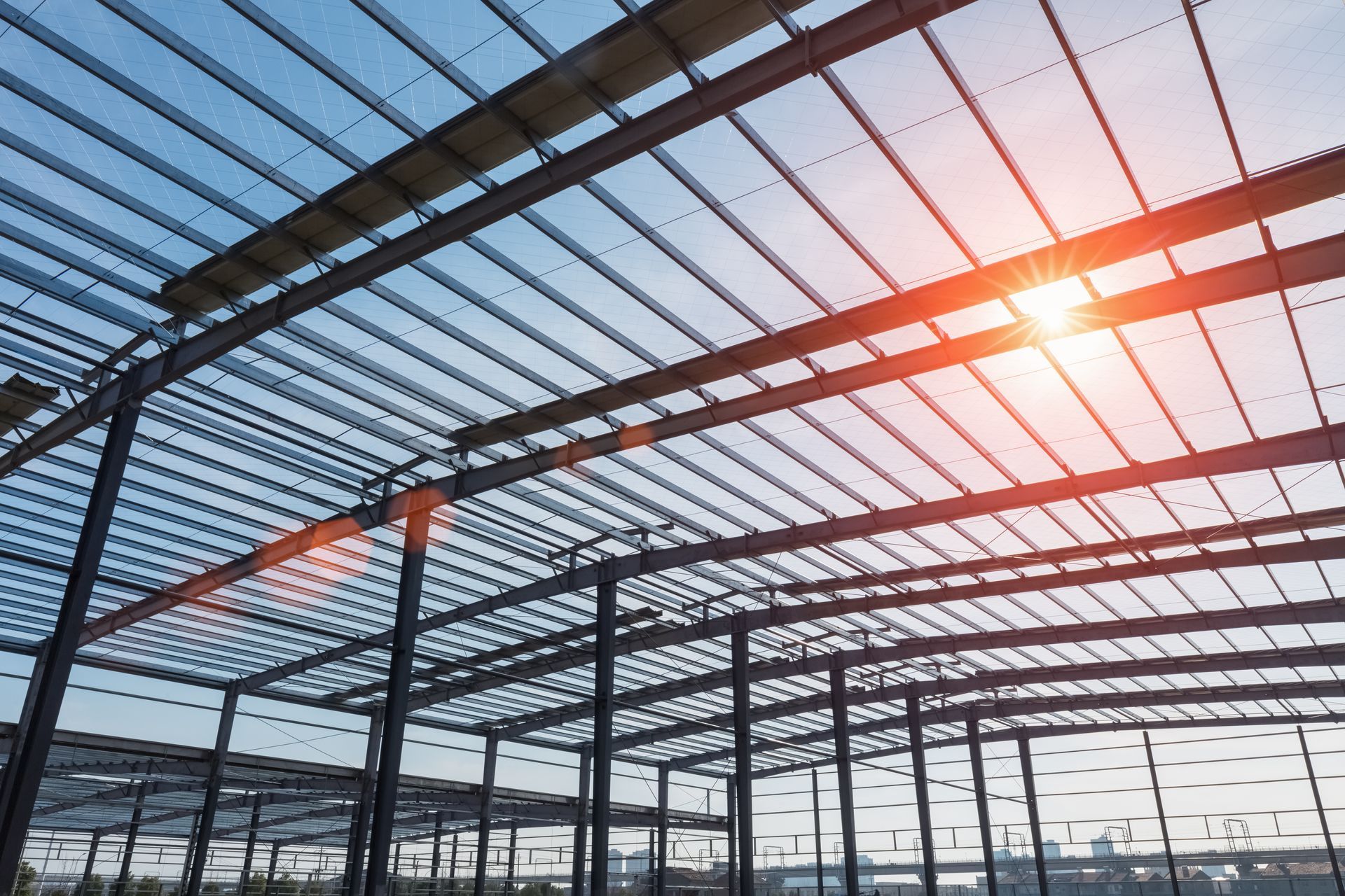 The sun is shining through the roof of a building under construction.