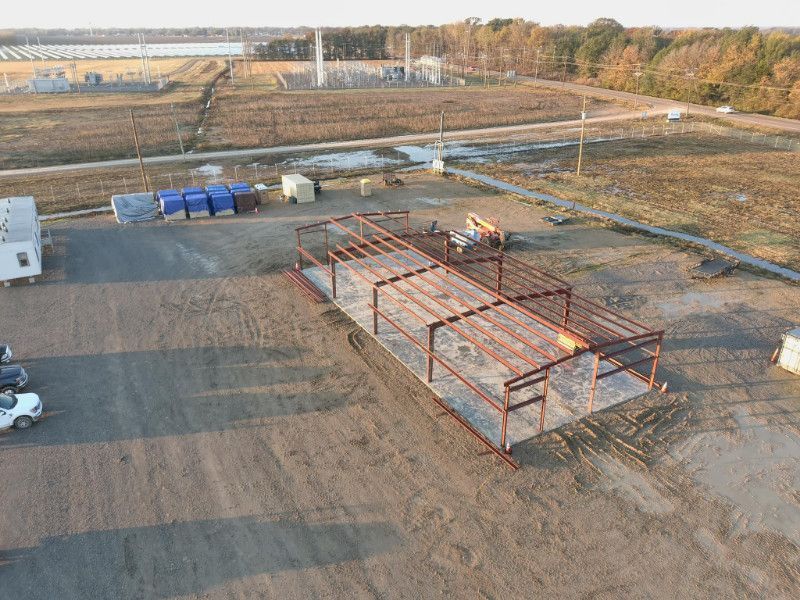 An aerial view of a building under construction in a field.