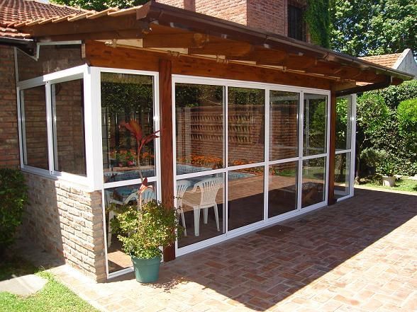 Un patio con muchas ventanas y sillas.