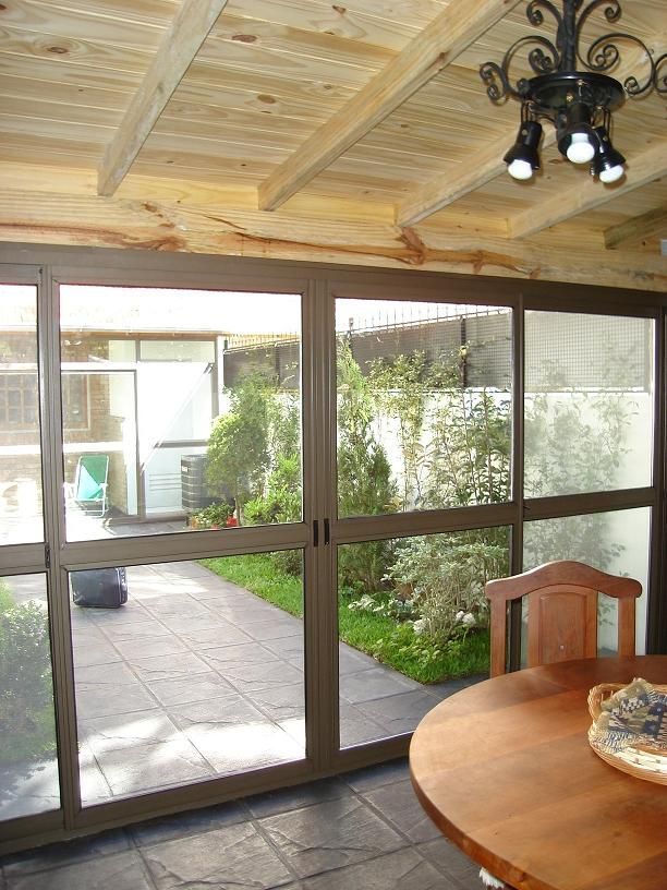 Una habitación con una mesa y sillas y puertas corredizas de vidrio.