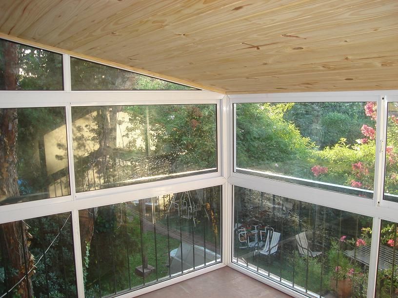 Un patio con muchas ventanas y sillas.