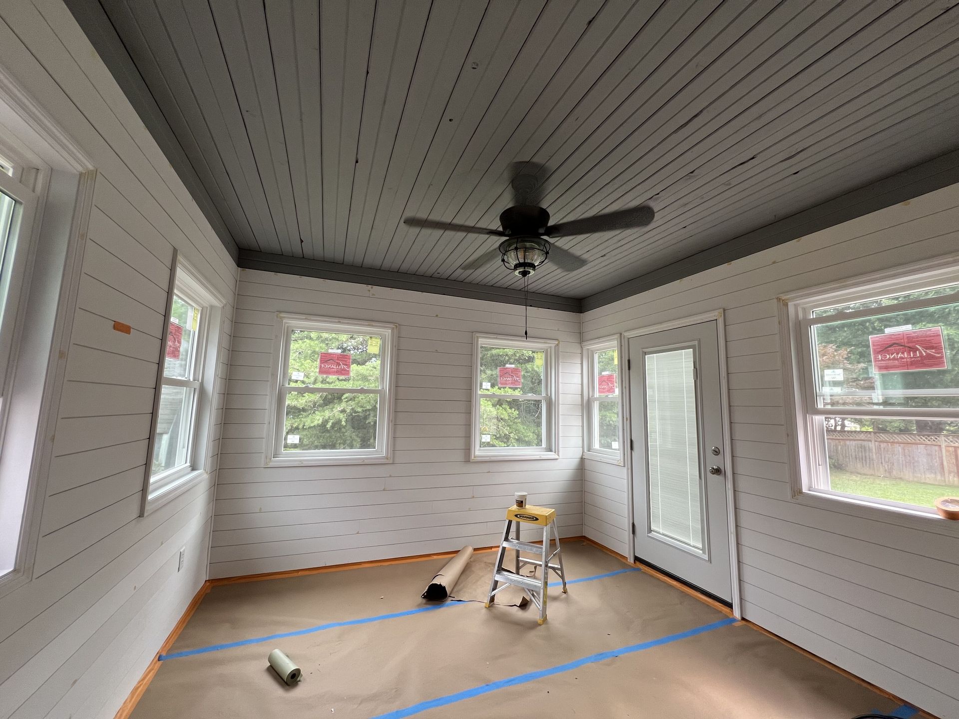 A room with white walls and a ceiling fan.