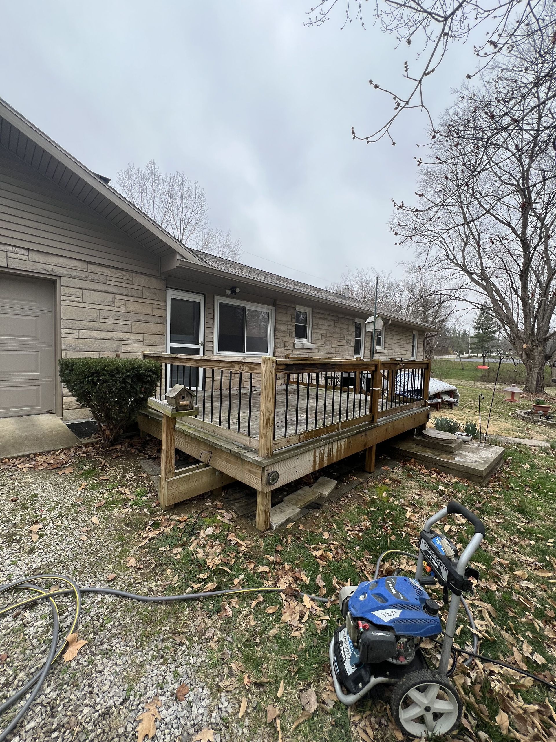 A house with a deck and a pressure washer in front of it.