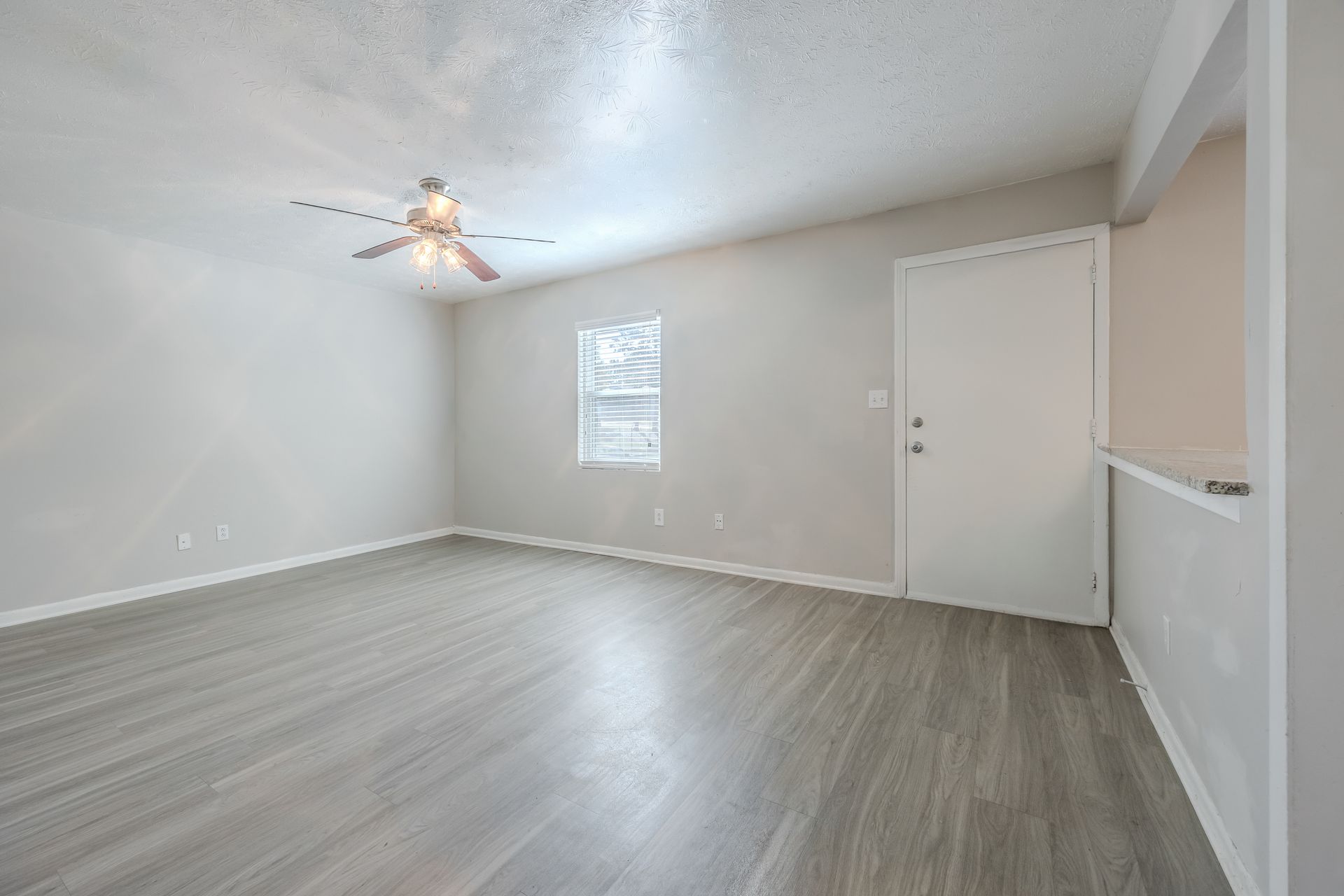 Brick building with white columns, door, and a brick walkway. Green lawn.