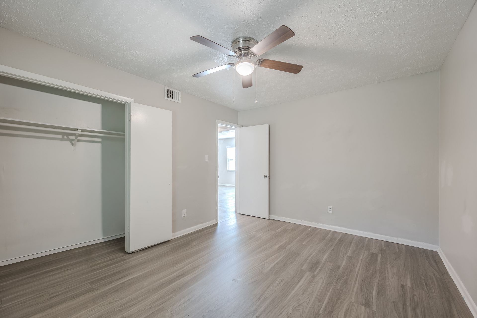 Gray kitchen with black appliances, white subway tile backsplash, and a window.