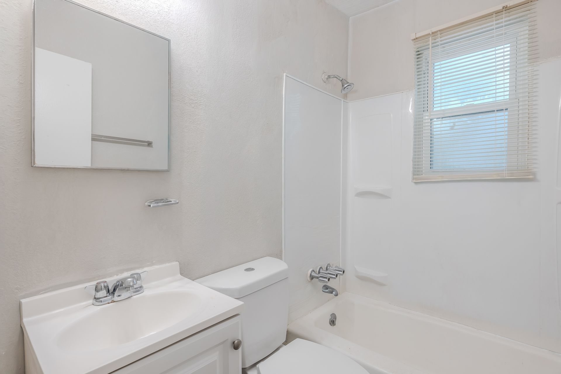 A small, modern kitchen with stainless steel appliances and white cabinets.