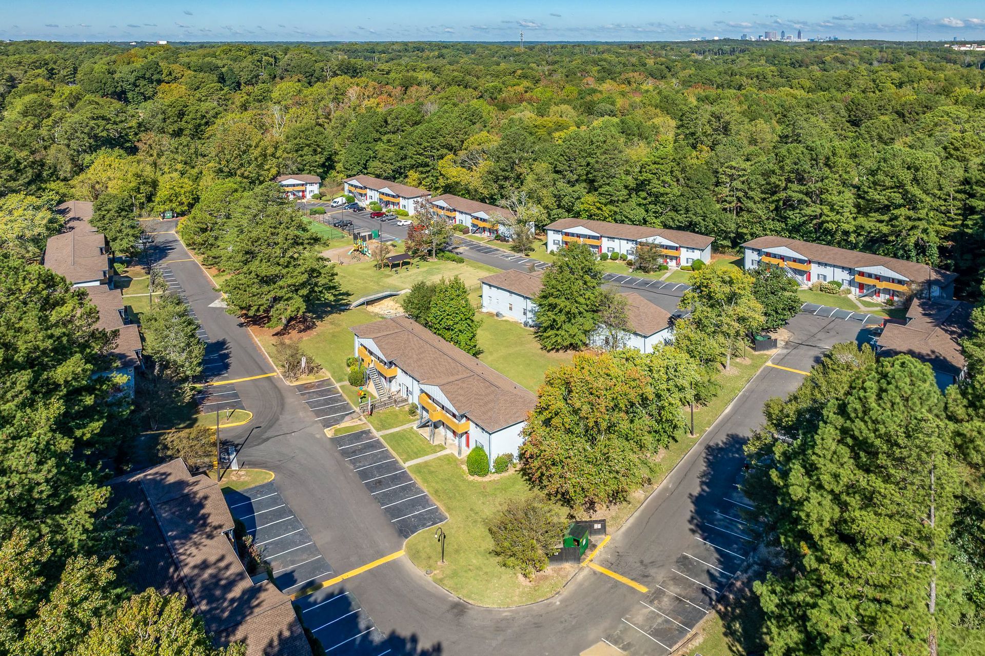 Brick building with white columns, door, and a brick walkway. Green lawn.