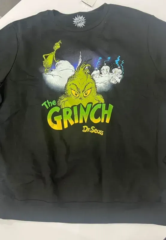 Black long-sleeve Grinch shirt laid flat on a white surface.