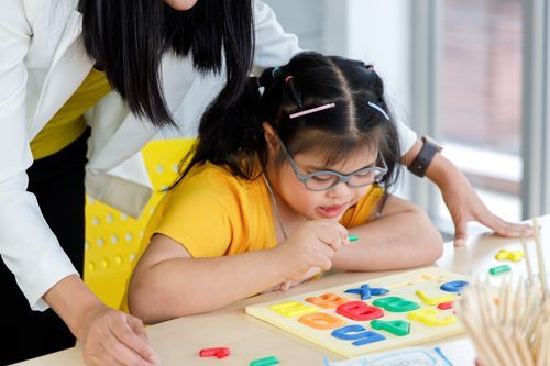 A Woman And A Little Girl Are Sitting At A Table In A Gym Playing With Toys - Valdosta, GA - Compass