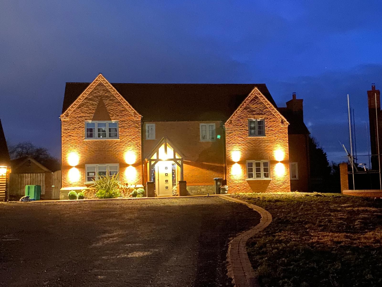 A large brick house is lit up at night